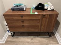 Front view of the dresser showing three drawers and cupboard, with various items placed on top.