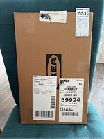 Photo of sealed brown cardboard box with Ikea logo, unopened.