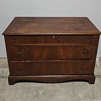 Front view of antique wooden dresser showing all four drawers and hardware.