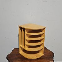 Front angle view of the corner desk bookcase showing four curved shelves and two vertical compartments for magazines or binders.