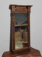 Full view of the Federalist style wall mirror showing the carved columns and the crown molding top