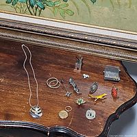 Overview of all jewelry pieces including leaf necklace, animal pins, grape pins, and keychains on a wooden surface.