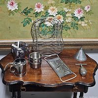 All nine kitchen accessory items displayed on a vintage wooden table against a floral wall background.