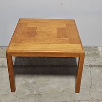 Front view of square teak Mid Century side table displaying parquet pattern top and straight square legs.