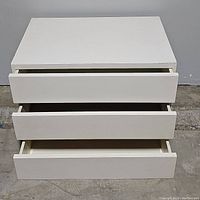 Front view of the white 3 drawer nightstand chest with drawers opened showing interior and drawer fronts.