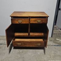 Front view showing two small top drawers, two pantry doors open, and one large bottom drawer.