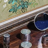 Overview photo showing perfume bottle, trinket box, mirror, and other items on wooden surface