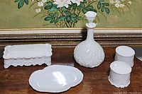 Group photo showing all items including milk glass decanter with stopper, two covered jars, trinket box, and plate.