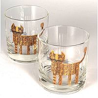 Photo showing pair of clear rocks glasses each with gold and black stylized cat graphic wrapping around perimeter.