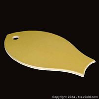 Photo of the top surface of the ceramic fish-shaped cheese board showing pale yellow glaze and fish shape with a hole for hanging