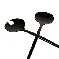 Pair of black modernist salad servers crossed on white background showing shape and finish.
