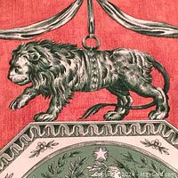 Close-up of a lion motif in black and celadon on pale rust background with decorative border details, part of the fabric's repeat pattern.