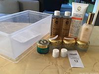 Set of skincare products and clear plastic container placed on table