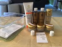 Full set of Elizabeth Grant Royale skincare products displayed on table including cleanser, toner, serum, day cream, night cream, eye cream, hand and foot cream, with clear plastic container.