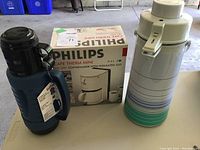 Philips Cafe Therm Mini Coffeemaker in box next to two different thermoses (Aladdin glass vacuum bottle in blue with black cover and Phoenix brand large thermos)
