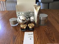 Full set of Elizabeth Grant skincare creams with various sized jars, tubes, and box on hardwood table.