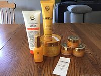 Full set of Elizabeth Grant Gold C creams and serums arranged on table showing various jar sizes and tubes.