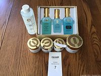 Photo showing entire set of Elizabeth Grant skincare products including three serums in box, toner bottle, and four cream jars with gold lids and labels.