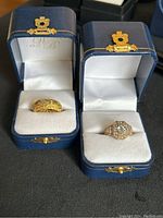 Two ornate rings in blue boxes, gold plated sterling silver ring with alexandrite and another with alexandrite and white sapphires