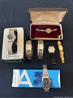 All watches displayed together on black cloth including box and velvet lined case.