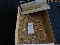 Box containing multiple gold toned necklaces and bracelets, and a Croton watch in its original box on top.