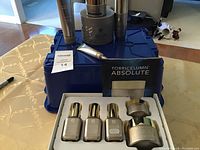 Photo of multiple Elizabeth Grant Torricelumn Absolute skincare bottles and jars with the product card in a blue plastic basket.