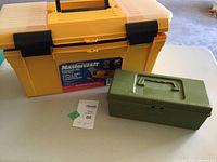 Photo showing large yellow Mastercraft toolbox next to small green Oxwall toolbox on a table in a garage setting.