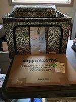 4 large sized leopard print collapsible storage totes unpacked along with a box labeled OrganizeMe 2-pack small storage bins in leopard print, stacked.