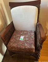 Front view showing woven chair with white back cushion and patterned seat cushion