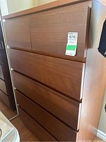 Front view of a wood-finish dresser with six drawers, part of the Ikea Malm series, showing condition and size.