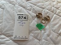 Front view of listing card and three gold rings