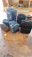 Full view of all luggage and cooler bags on wooden floor, showing the different styles and sizes.