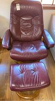 Front view of burgundy leather recliner and ottoman on wood swivel bases