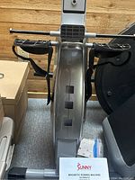 Top view of the footrest and handlebar area of Sunny magnetic rowing machine showing strap pedals and central flywheel casing with model number visible.