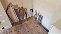 Photo showing all hand saws and angle squares lined up against a wall.