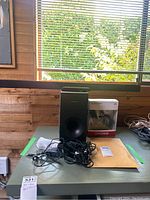 Koss headphones in retail box and Samsung subwoofer on table with cables and remote.