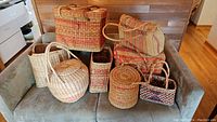 All baskets and totes displayed on a couch showing variety of shapes and sizes.