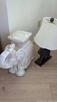 White ceramic elephant decorative figurine/stool with detailed patterning and raised trunk seen from multiple angles.