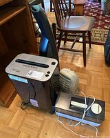 Space heaters, humidifier, paper shredder placed on the floor near wooden furniture.