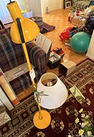 Photo of the yellow floor lamp next to couch and other household items showing its style and height.