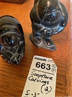 Photo showing both soapstone carvings side by side, viewed from above and front angles.