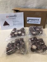 Four plastic bags containing multiple shank mounted flap wheels, with a box and product info card labeled Goxawee in the background.