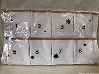 Photo showing first 8 pockets numbered 1 through 8 of the 24-pocket canvas advent calendar in plastic packaging.