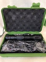 Two black tactical style laser lights in green hard case with foam cutouts