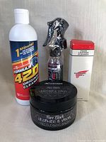 Photo of 4 car care products: Formula 420 Original Cleaner, Method Leather & Vinyl Cleaner spray, Redwing Shops Foam Leather Cleaner, Pure Black Leather & Vinyl Recoloring Balm.