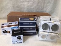 Lot contents including white cardboard coin holders, labeled boxes, magnifier, penny paper rollers.
