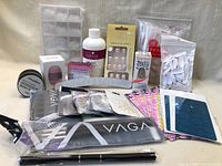 Full lot showing nail tips, nail gel essence, press-on nails, nail polish strips, nail art stickers, acrylic powder, files, detail brush pen, and practice hand.