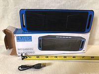 Photo of Megabass A29P wireless speaker on box with measuring tape showing size and included USB cable.