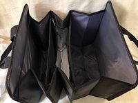 Full view of the black trunk organizer showing three compartments including insulated section inside.