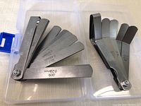 Open view of one stainless steel measuring gauge set with blades spread showing various measurement markings from 0.009 inches (0.23 mm) to 0.030 inches (0.76 mm).